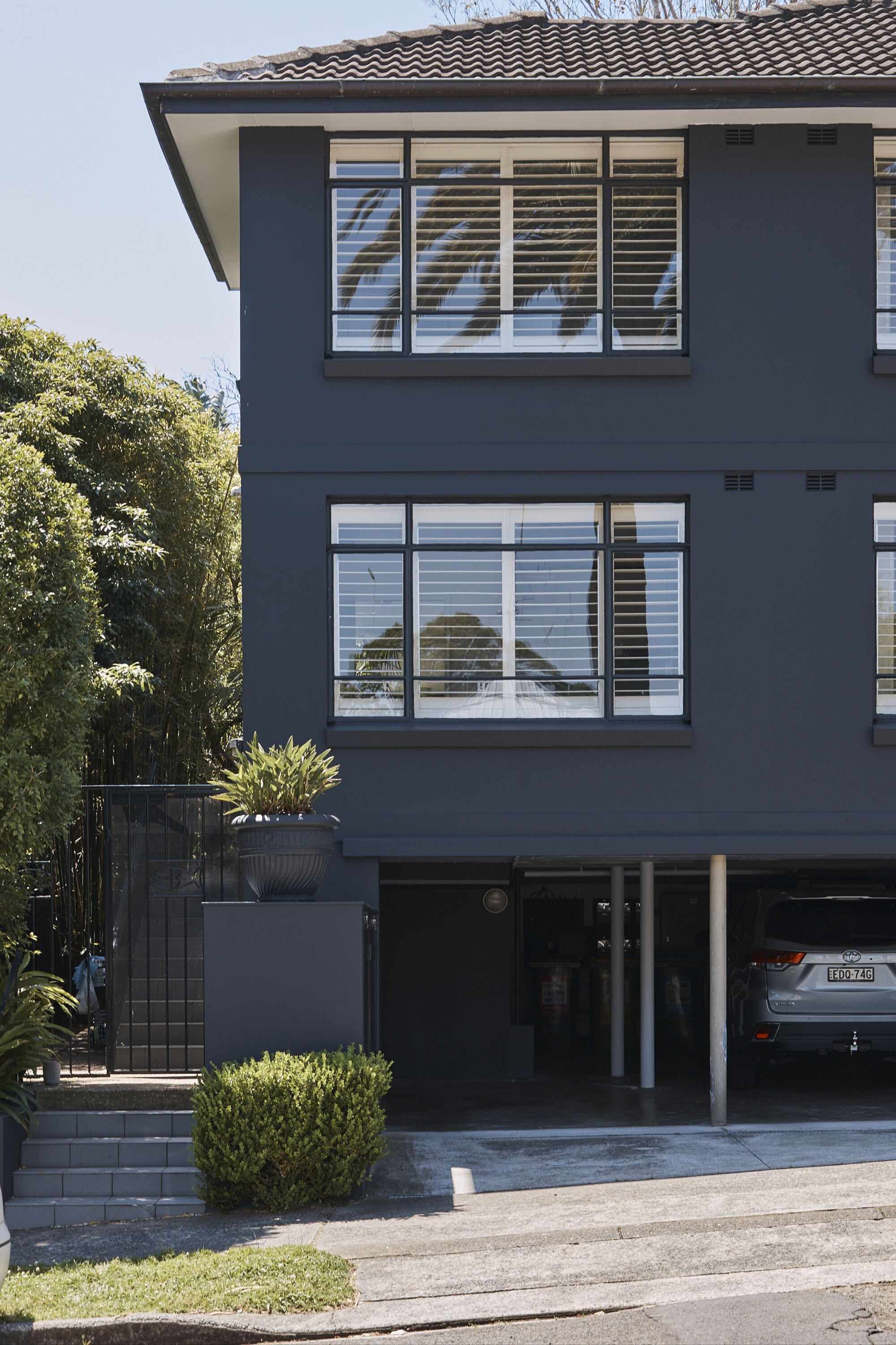 Un edificio moderno a due piani con ampie finestre e un garage.