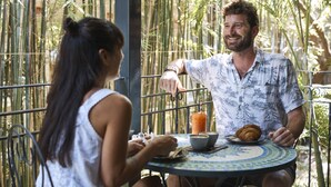 Una pareja cenando en una mesa al aire libre con vistas a plantas de bambú.