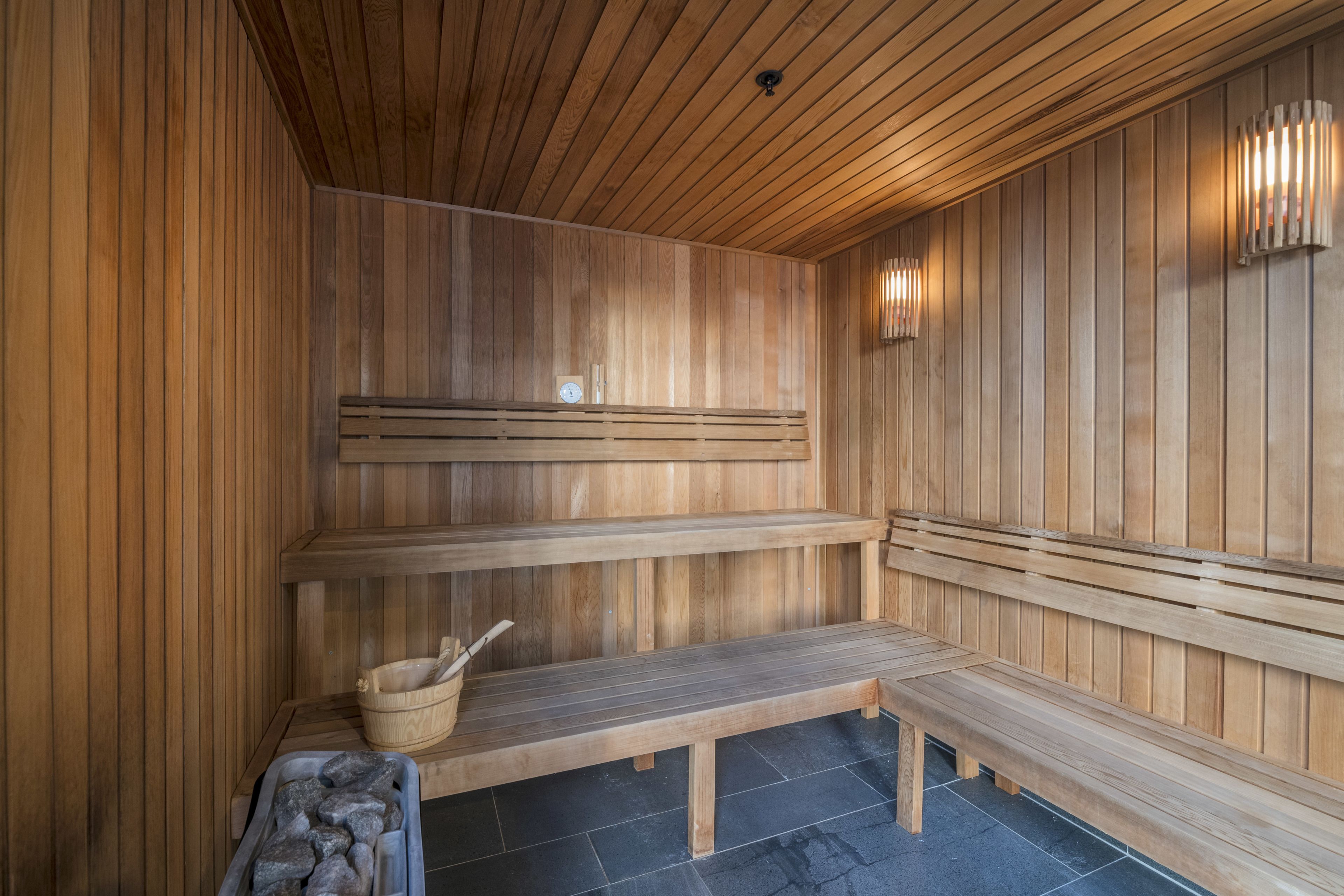 Eine Sauna mit Holzbänken und einer Steinsinne.