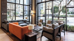 Un interior moderno con ventanas amplias, un sofá, sillones y una mesa de centro.