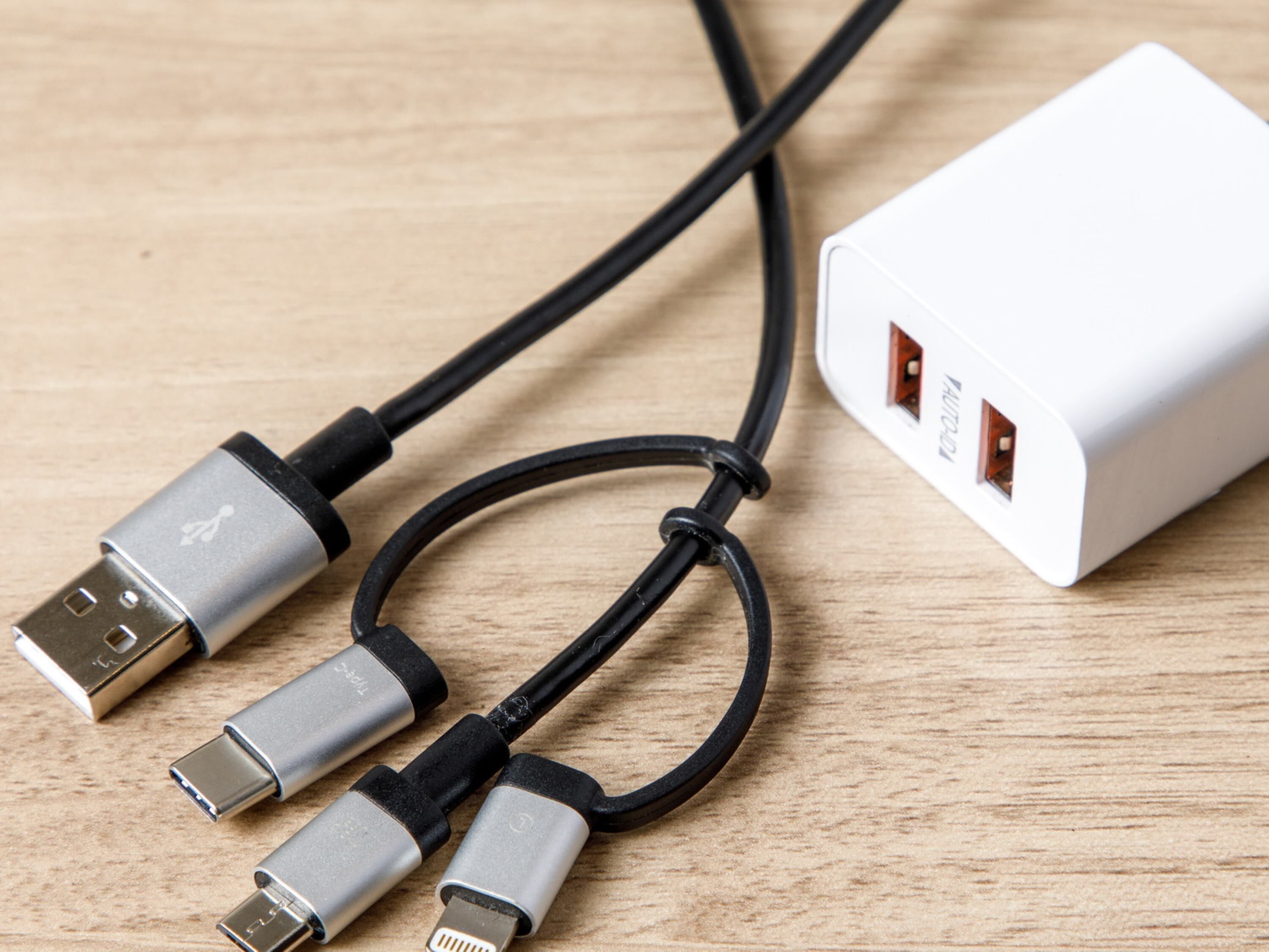 Une multiprise blanche dotée de trois ports USB et d’un câble qui y est connecté.