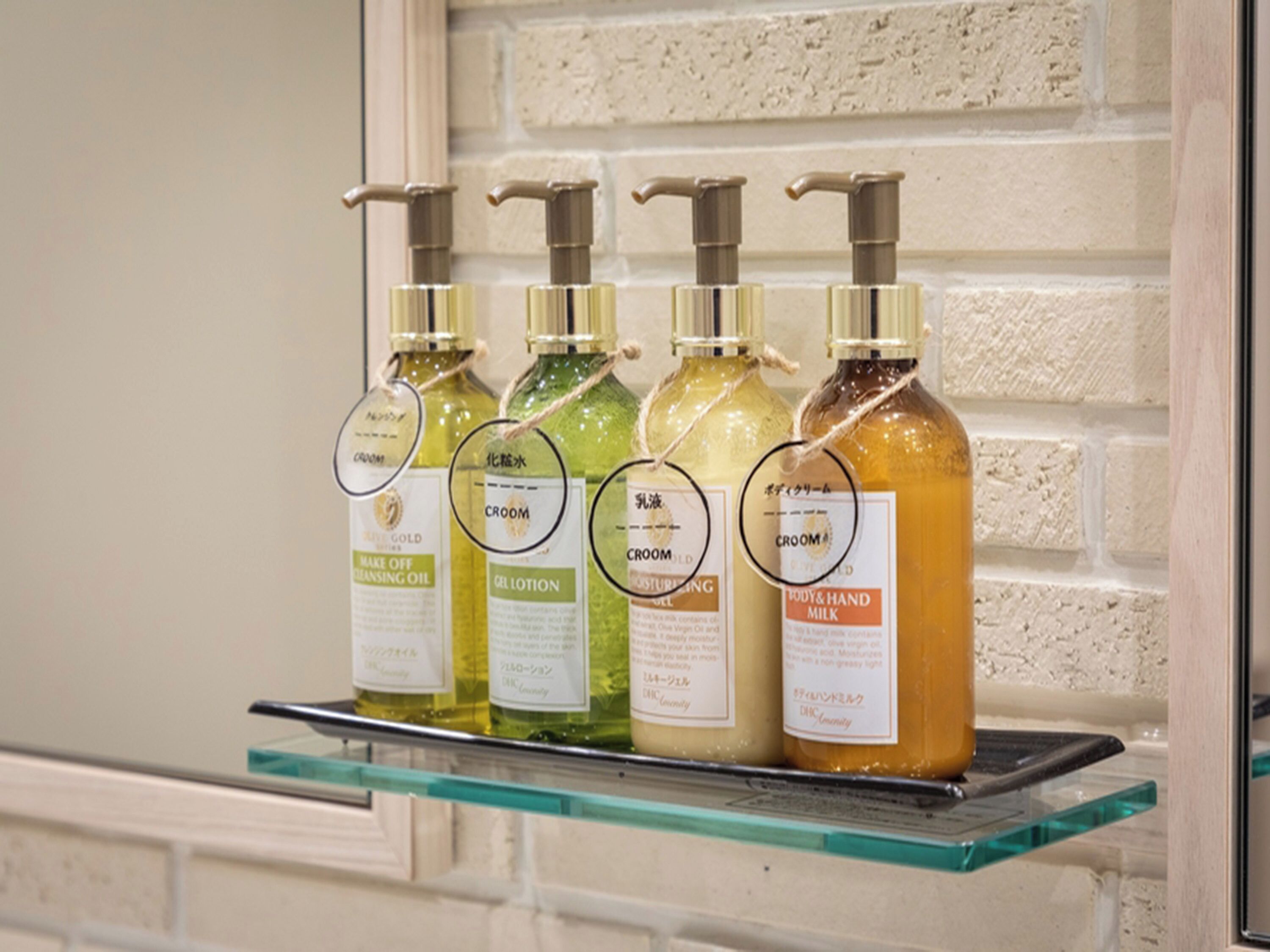 A shelf with four bottles of body care products.