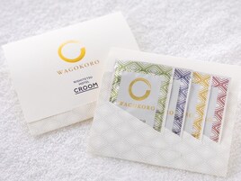 Une enveloppe blanche ornée d’un motif géométrique et une carte portant le logo « WAGOKORO » et le texte « NISHITETSU HOTEL CROOM ».