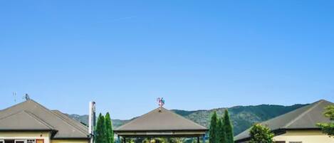 Ein Gebäude mit überdachter Einfahrt, blauem Himmel und Bergen im Hintergrund.