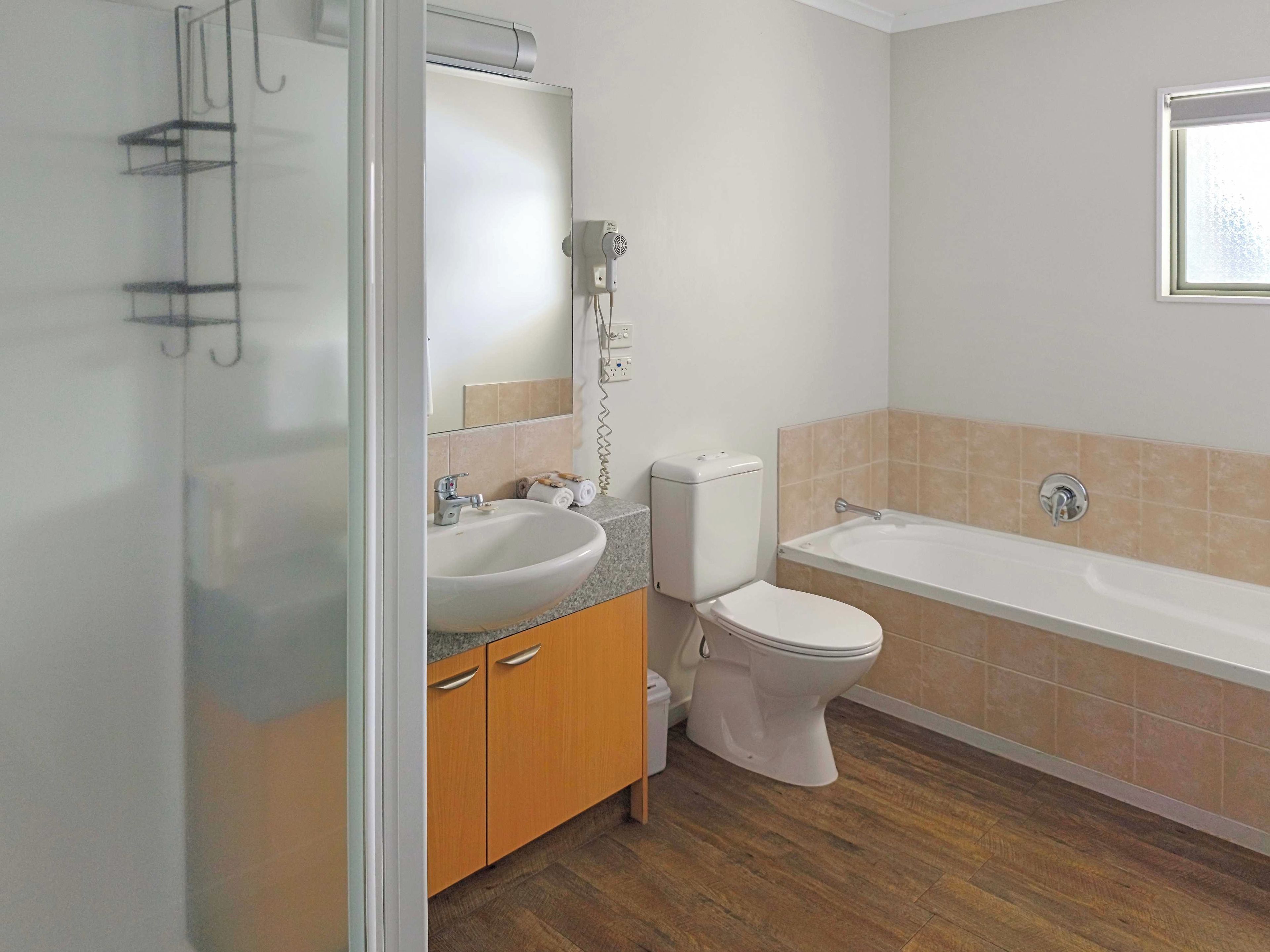 Un baño con lavamanos, inodoro y bañera.