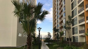 A pathway flanked by greenery and a multi-story building with balconies. - KSL Hot Spring Resort (Johor Bahru)
