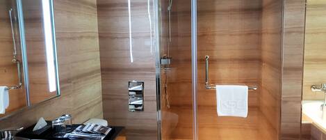 A modern bathroom with a glass-enclosed shower, a white sink, and a toilet.