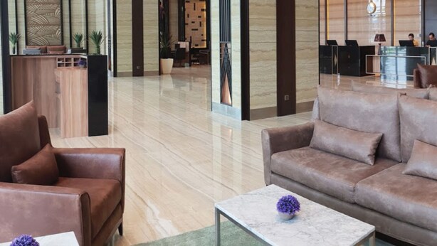 A modern lobby with a reception desk, seating area, and a view into a dining area. - KSL Hot Spring Resort (Johor Bahru)
