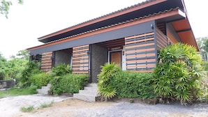 Un bâtiment moderne doté d’un toit en pente, de lambris en bois sur la façade et d’une petite entrée.