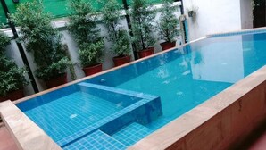 A rectangular swimming pool with blue tiles and a tiled deck area. - Angkor Sangrith Hostel (Siem Reap)