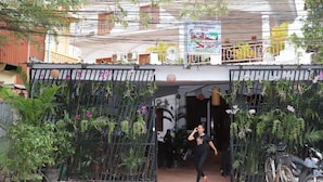 A gated entrance with potted plants and a signboard. - Angkor Sangrith Hostel (Siem Reap)