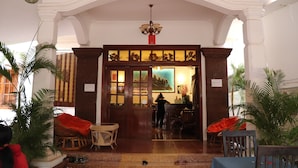 An interior with a wooden door, a chandelier, and potted plants. - Angkor Sangrith Hostel (Siem Reap)