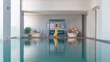 Una piscina techada, sillones reclinables de piscina