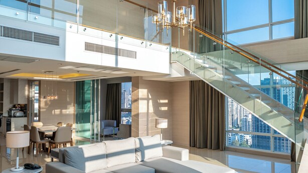 A modern living room with a sofa, coffee table, and a staircase leading to an upper floor. - Jasmine 59 Hotel Thonglor Bangkok (Bangkok)