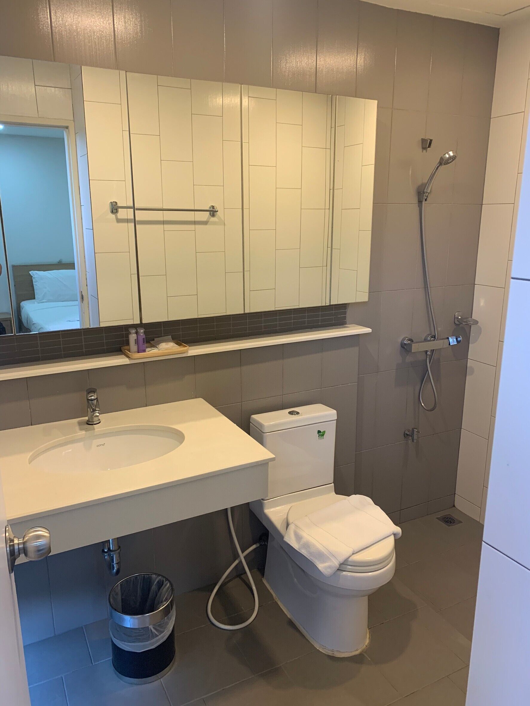 A modern bathroom with a white sink, toilet, and shower.