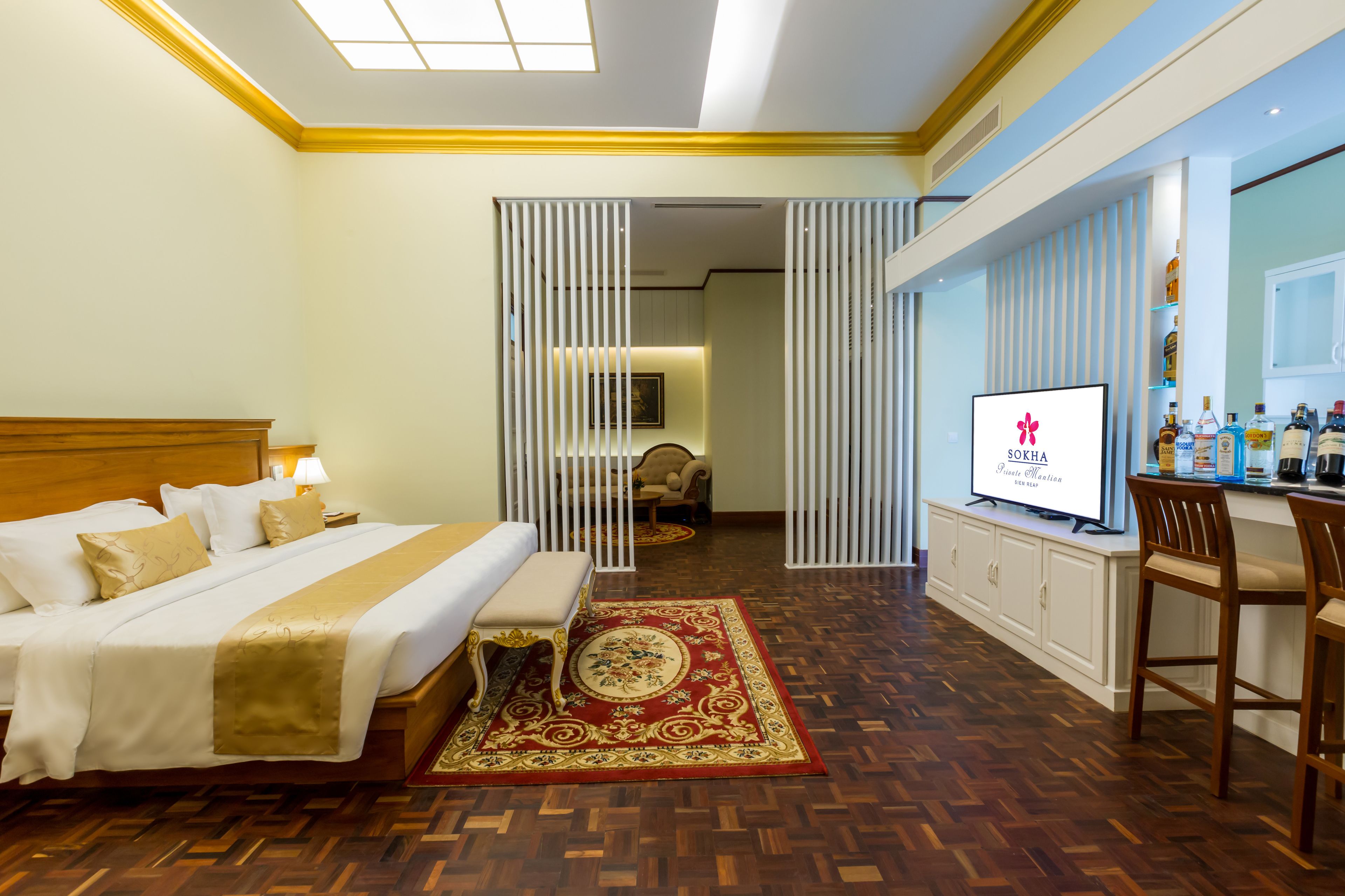 Une chambre d’hôtel équipée d’un lit, d’un bureau, d’une télévision et d’un mini-bar.