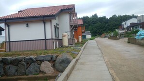 Ein Wohngebiet mit Häusern, einem Betonweg und Flüssiggastanks.