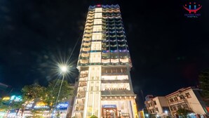 Un hotel de varios pisos con balcones iluminados y una entrada bien iluminada.