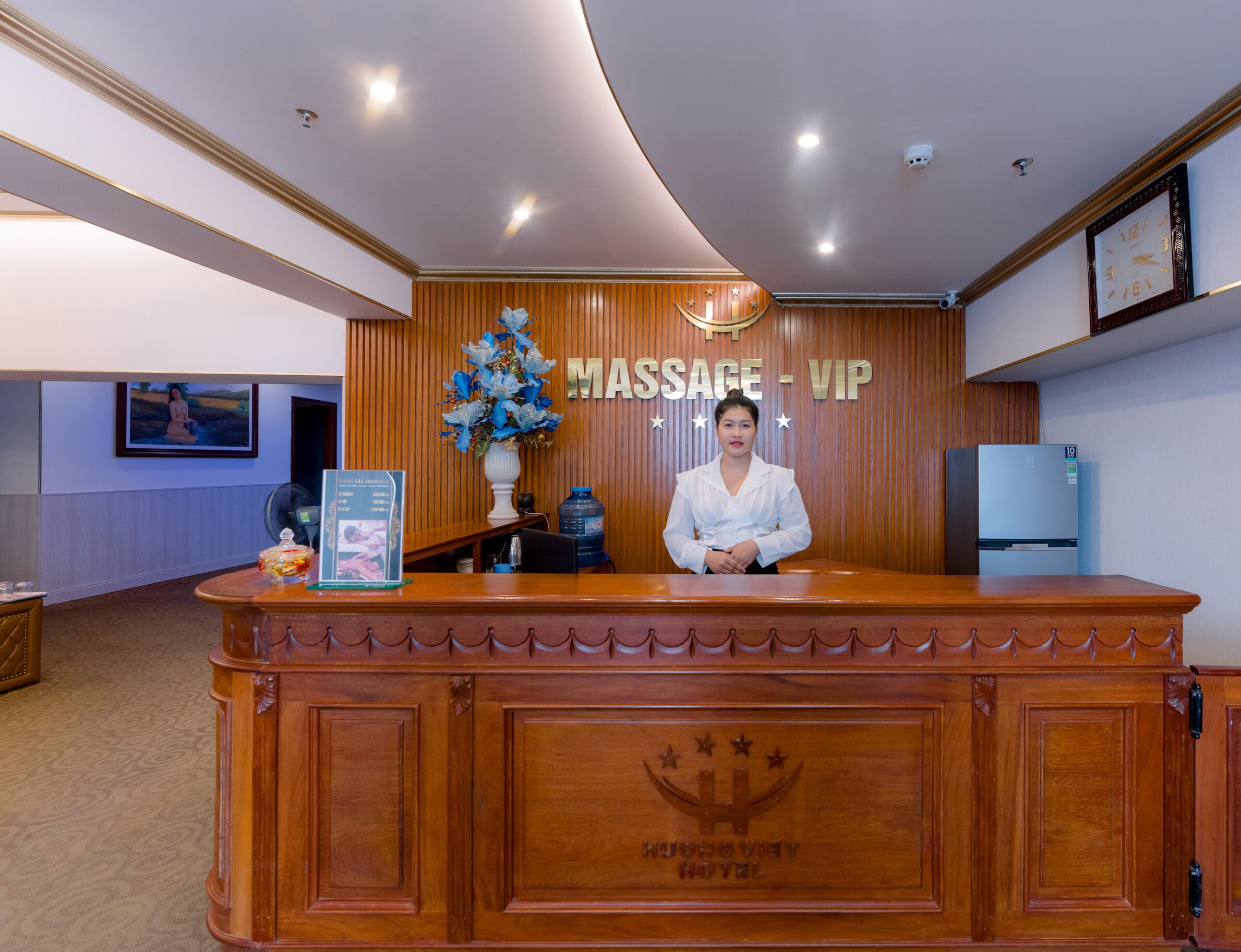 Una mesa de recepción con un cartel que dice "MASSAGE - VIP" y el logotipo del HOTEL HUNG VIEN.