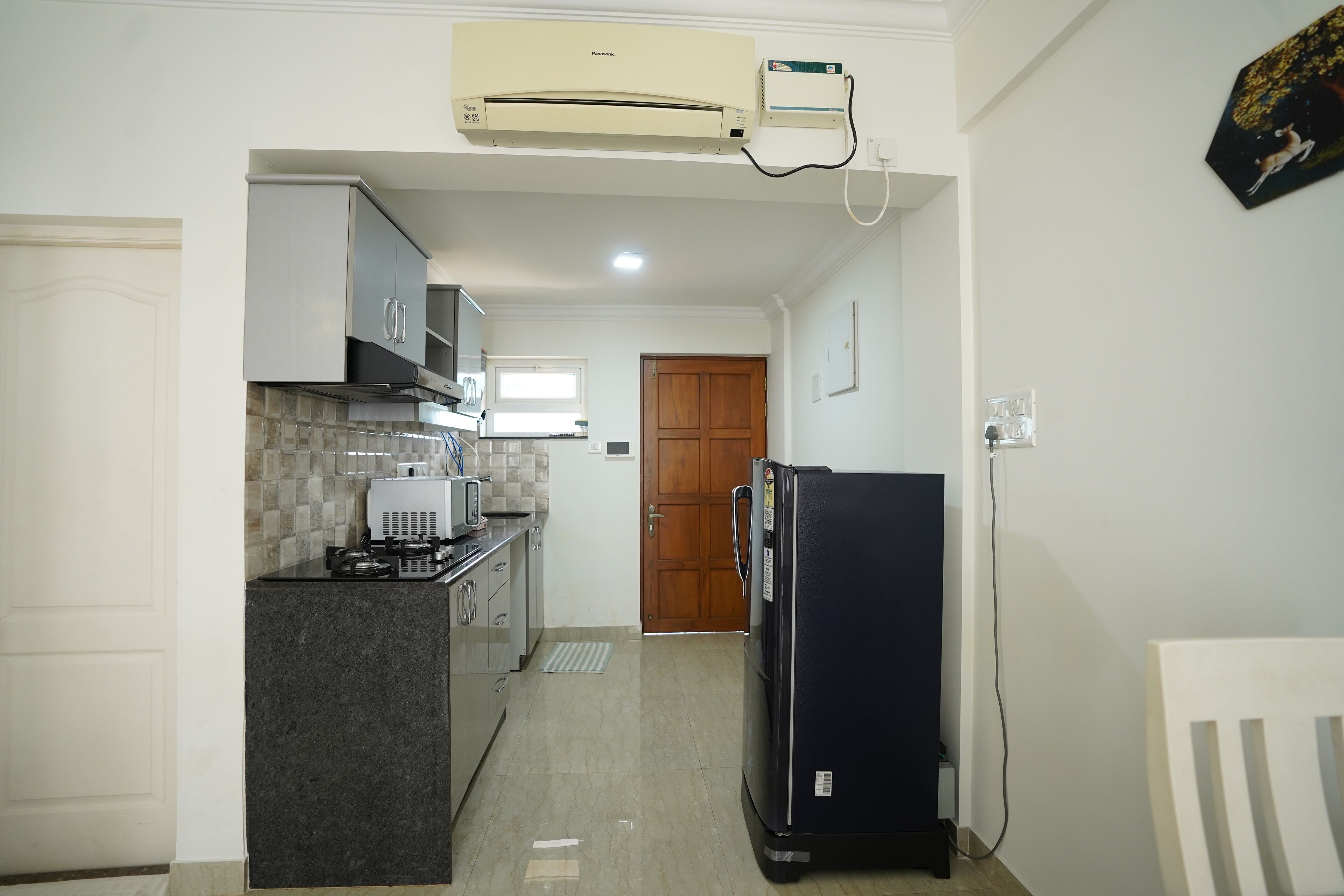 A compact kitchen with a stove, microwave, and refrigerator.