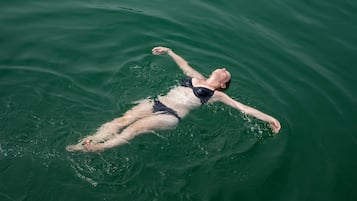 Iemand drijft op het water in een zwempak.