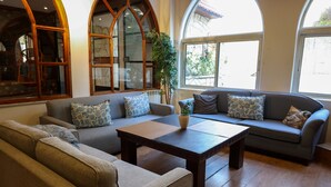 Un amplio salón con un sofá, una mesa de centro y un gran ventanal de arco.