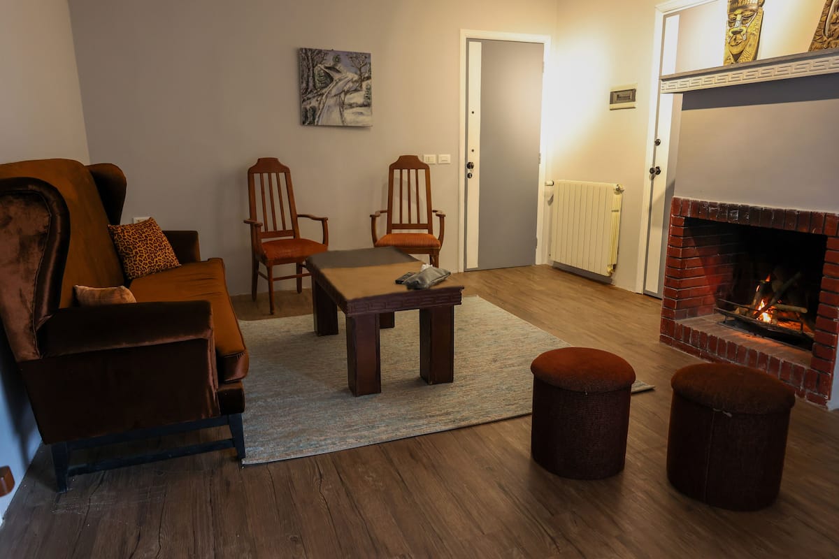 Un salon confortable avec un canapé, des fauteuils, une table basse et une cheminée.