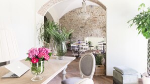 A dining area with a laptop on a table, a vase with flowers, and a chandelier. - Agave in città (Livorno)