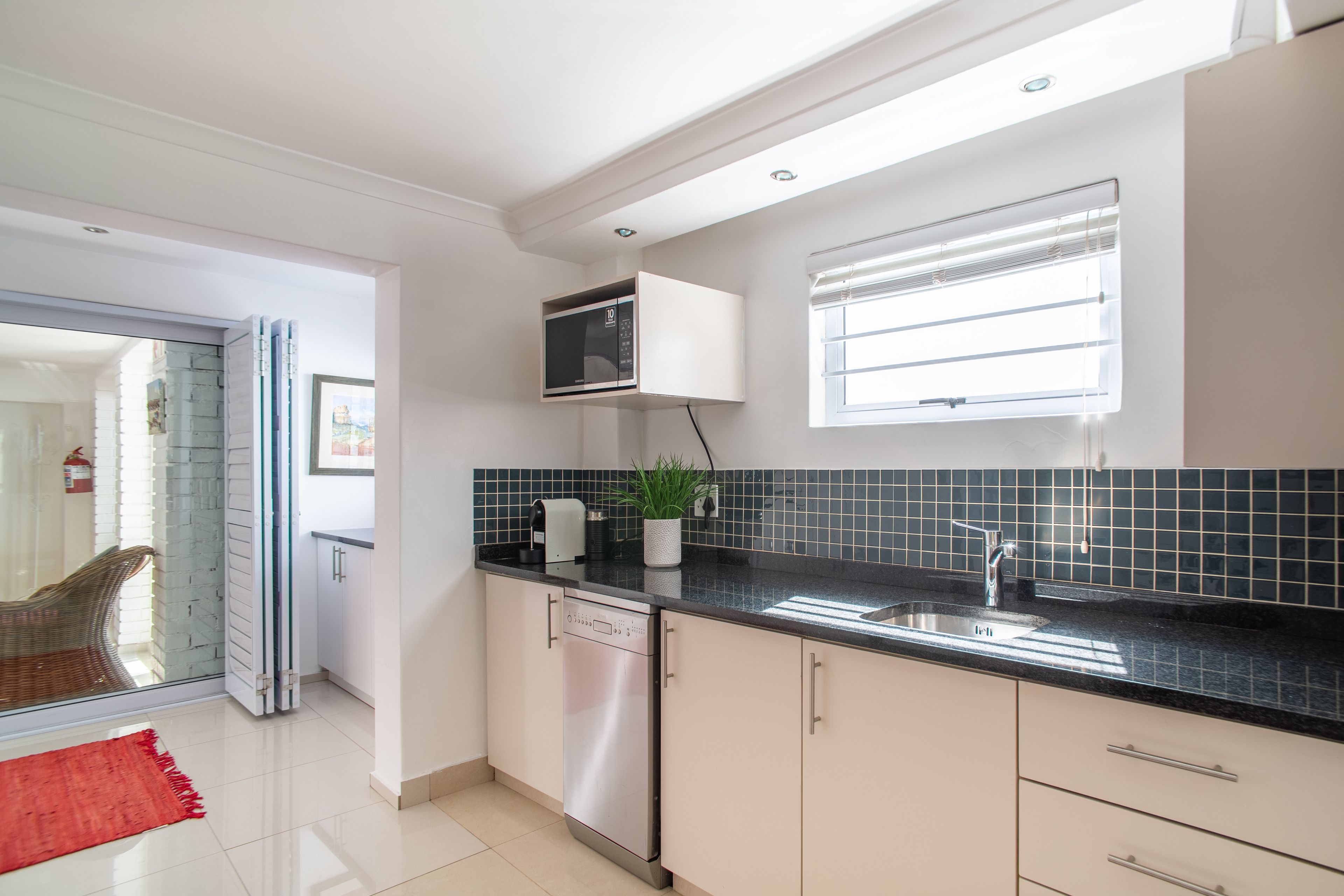 A modern kitchen with a dishwasher, microwave, and sink.