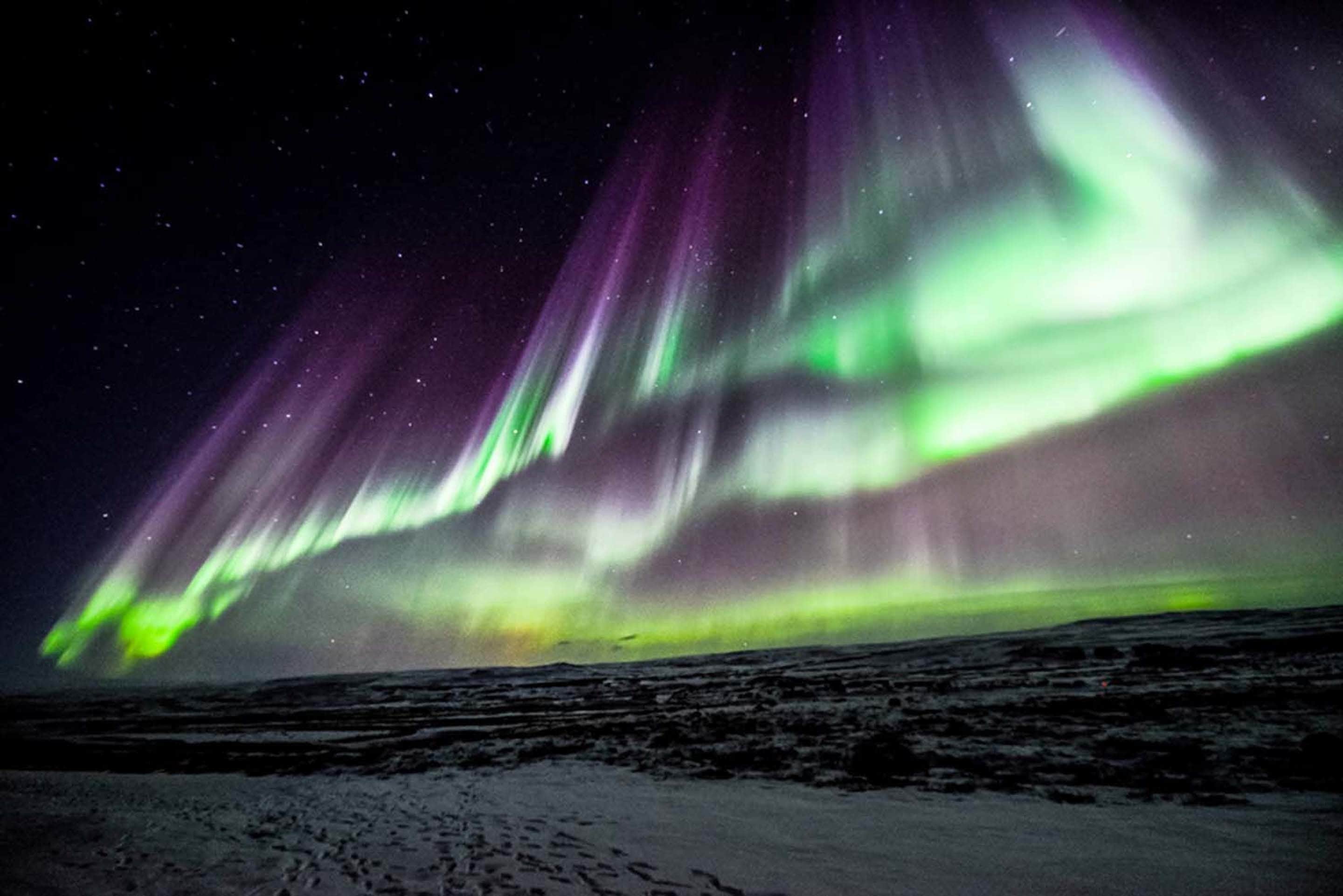 A snowy landscape with aurora borealis.