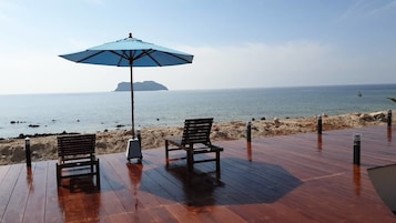 Una piscina al aire libre, sombrillas, sillones reclinables de piscina