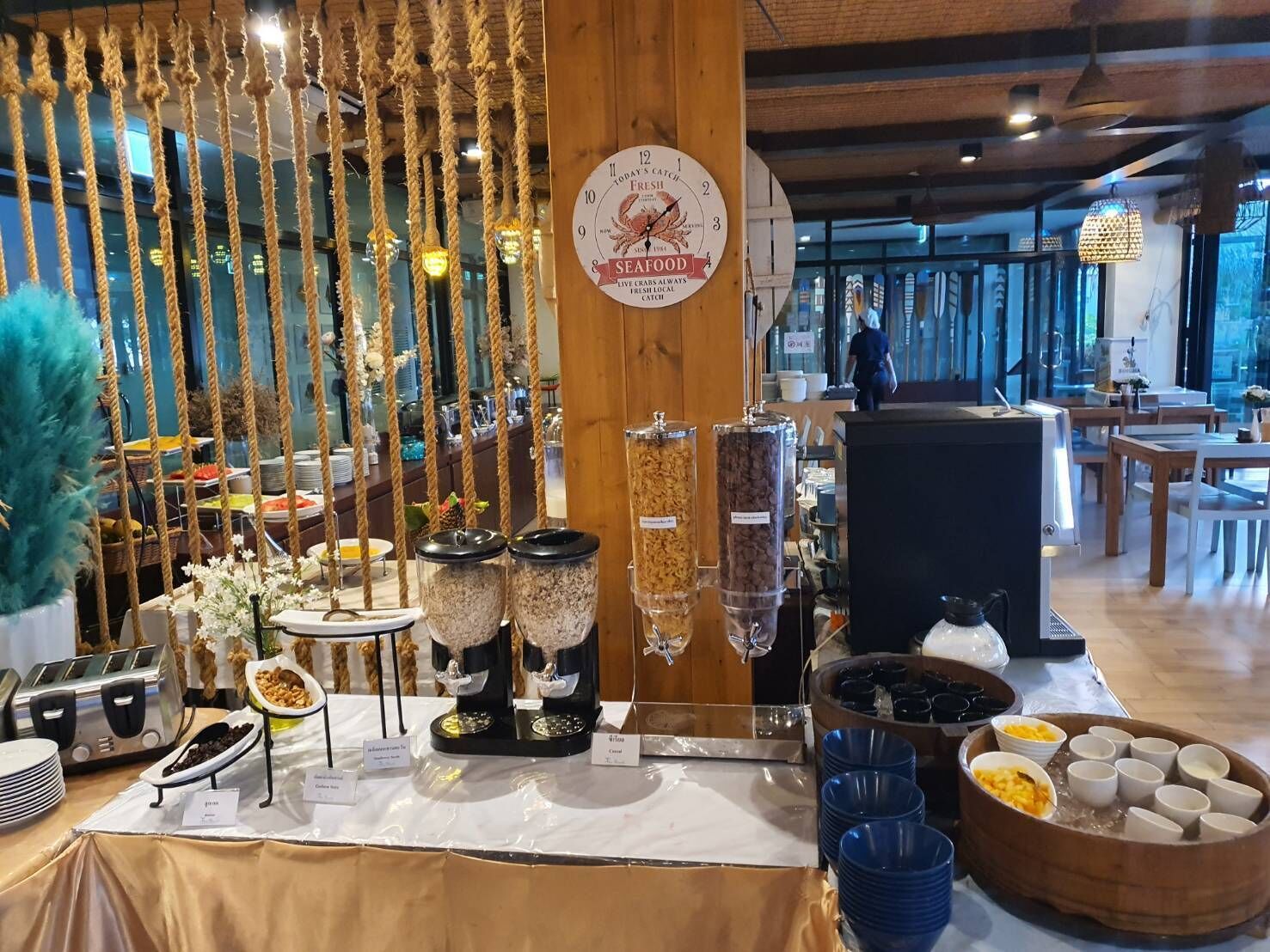 A buffet setup with various food containers and a clock displaying the time.