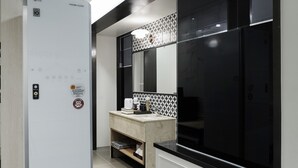 A modern kitchen with a built-in LG refrigerator, a large black-framed window, and a tiled backsplash. - Gracias Hotel Gimhae (Gimhae)