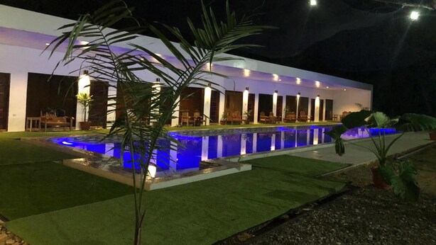 A modern building with a pool and outdoor seating area. - Alesseo Backpackers - Hostel (Puerto Princesa)
