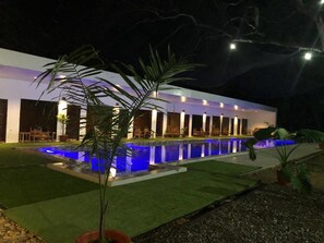 A modern building with a pool and outdoor seating area. - Alesseo Backpackers - Hostel (Puerto Princesa)