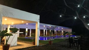 An outdoor area with a pool, seating, and potted plants. - Alesseo Backpackers - Hostel (Puerto Princesa)