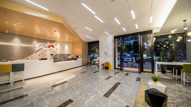 A modern reception area with a marble floor, a reception desk, and a glass door leading outside. - Borrman Hotel Canton Tower Kecun Station (Guangzhou)