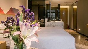 A modern hotel room with a large bed, a bathroom with a marble countertop, and a vase of flowers on the nightstand. - Borrman Hotel Canton Tower Kecun Station (Guangzhou)