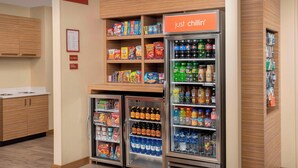 A kitchenette with a refrigerator stocked with beverages and snacks, a microwave, and a coffee machine. - TownePlace Suites by Marriott College Park (College Park)