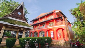 A red building with a sign that says "TAXI" and a covered area with a roof.