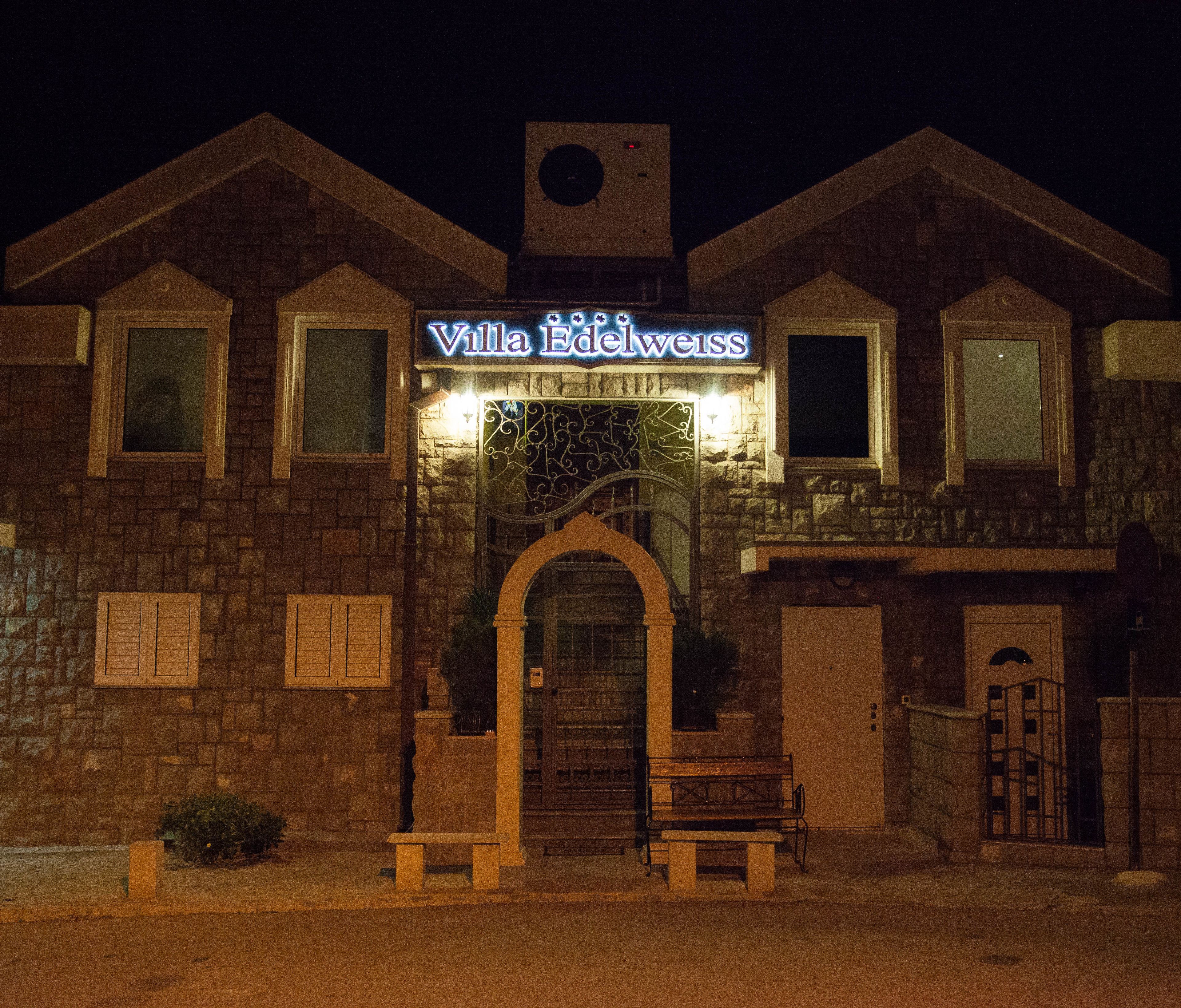 Villa Edelweiss con fachada de piedra, una entrada central y un letrero sobre la puerta.