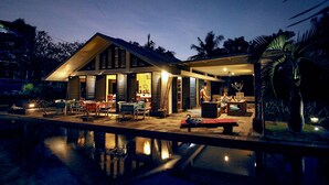 A modern house with a pool, featuring a dining area, a living room, and a kitchen. - Le Mirage Villa Santai (Sukasada)