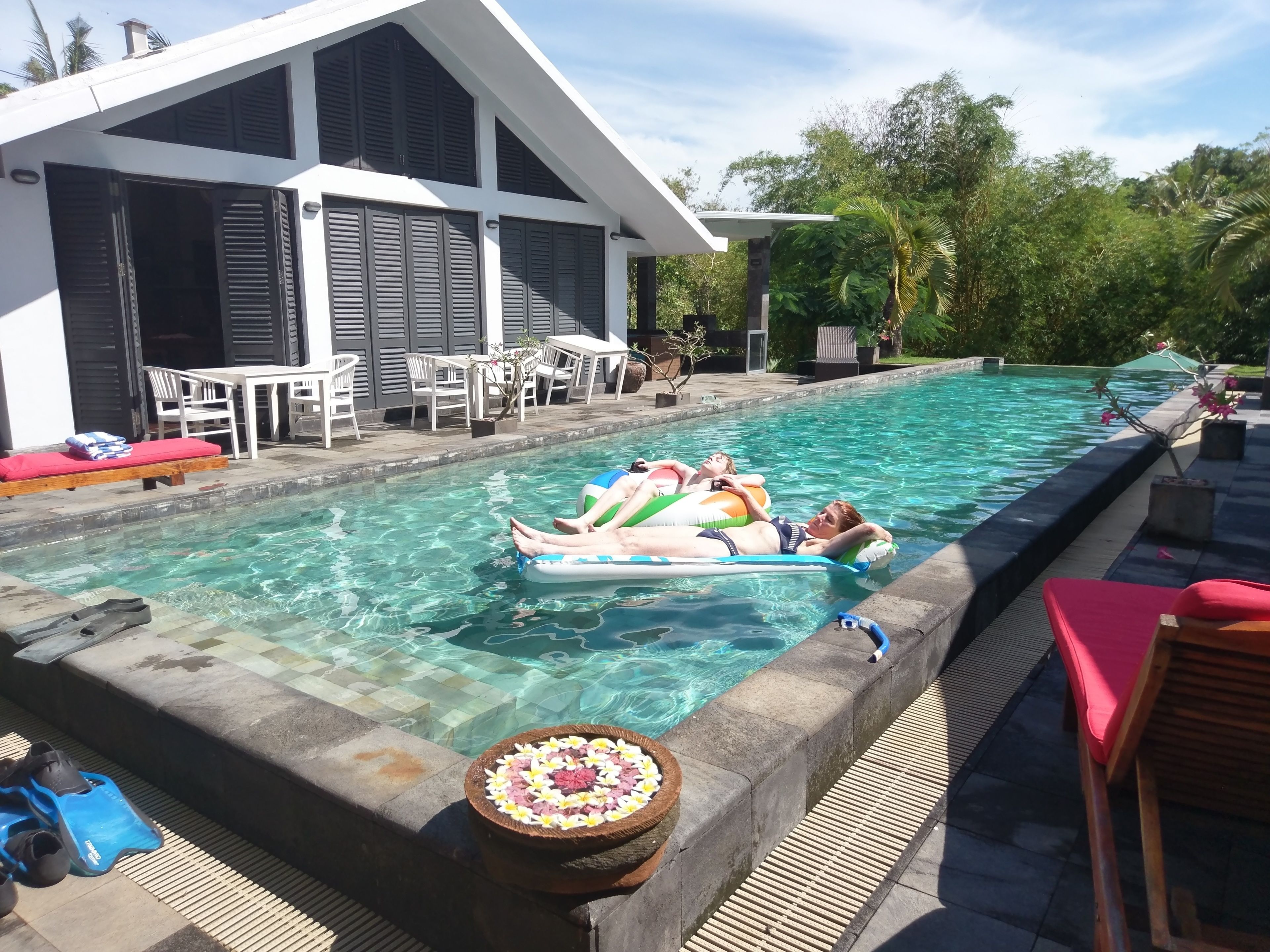 Una piscina al aire libre, sillones reclinables de piscina