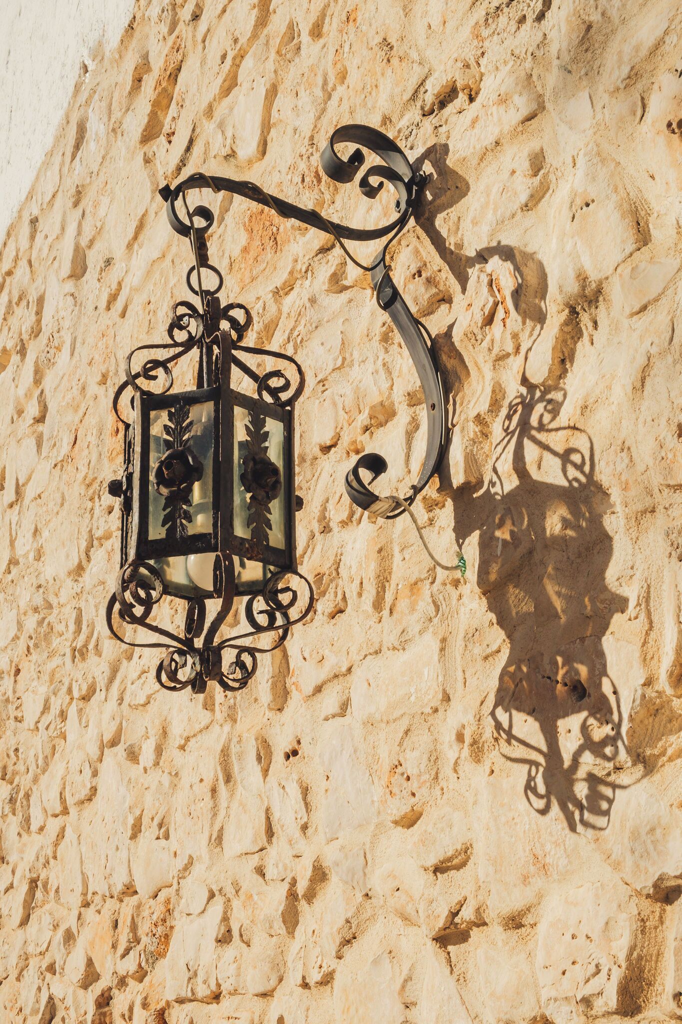 Una lámpara de metal fijada en una pared con textura.
