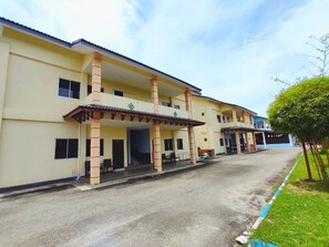 A multi-story hotel with a covered entrance and outdoor seating area. - Shell Out Cenang Beach Resort (Langkawi)
