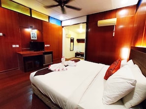 A hotel room with a bed, a desk with a television, and a mirror. - Shell Out Cenang Beach Resort (Langkawi)