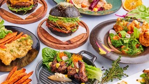 A variety of dishes including burgers, grilled chicken, and salads, presented on wooden boards and plates. - Hotel Verdandi Oslo (Oslo)