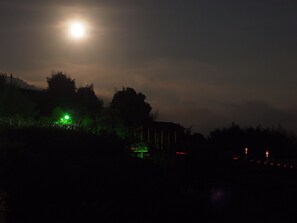 A night scene with a bright moon, a green-lit structure, and a building silhouette. - Sunrise235 (Zhuqi)