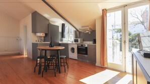Eine moderne Küche mit Essbereich, integrierten Geräten und einem großen Fenster.