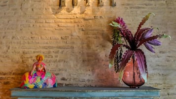 Un vestíbulo con un cartel que dice "LOBBY HOTEL", una mesa decorativa y un jarrón con flores.